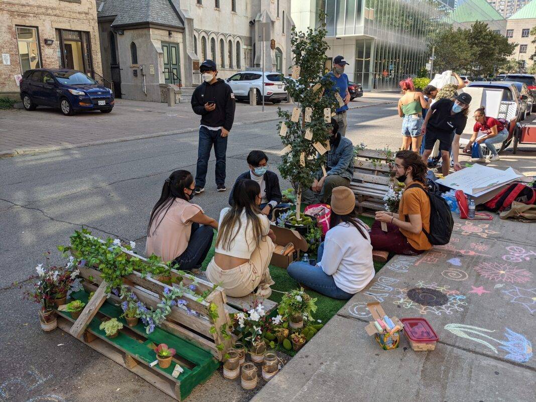 Students gather in a makeshift park built in a parking spot on the street in Toronto.