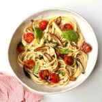 shiitake and cherry tomato pasta served in a bowl