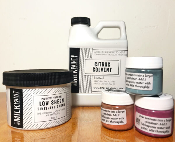 A grouping of products from The Real Milk Paint Co., including paints, finishing creams, and stripper.