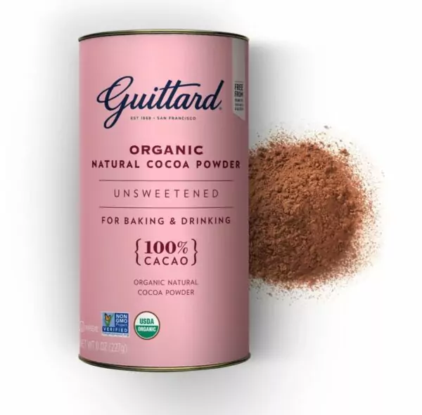 A pale pink canister of organic, 100% cocoa powder from American chocolate brand Guittard, with a small pile of cocoa powder on the right side of the canister.