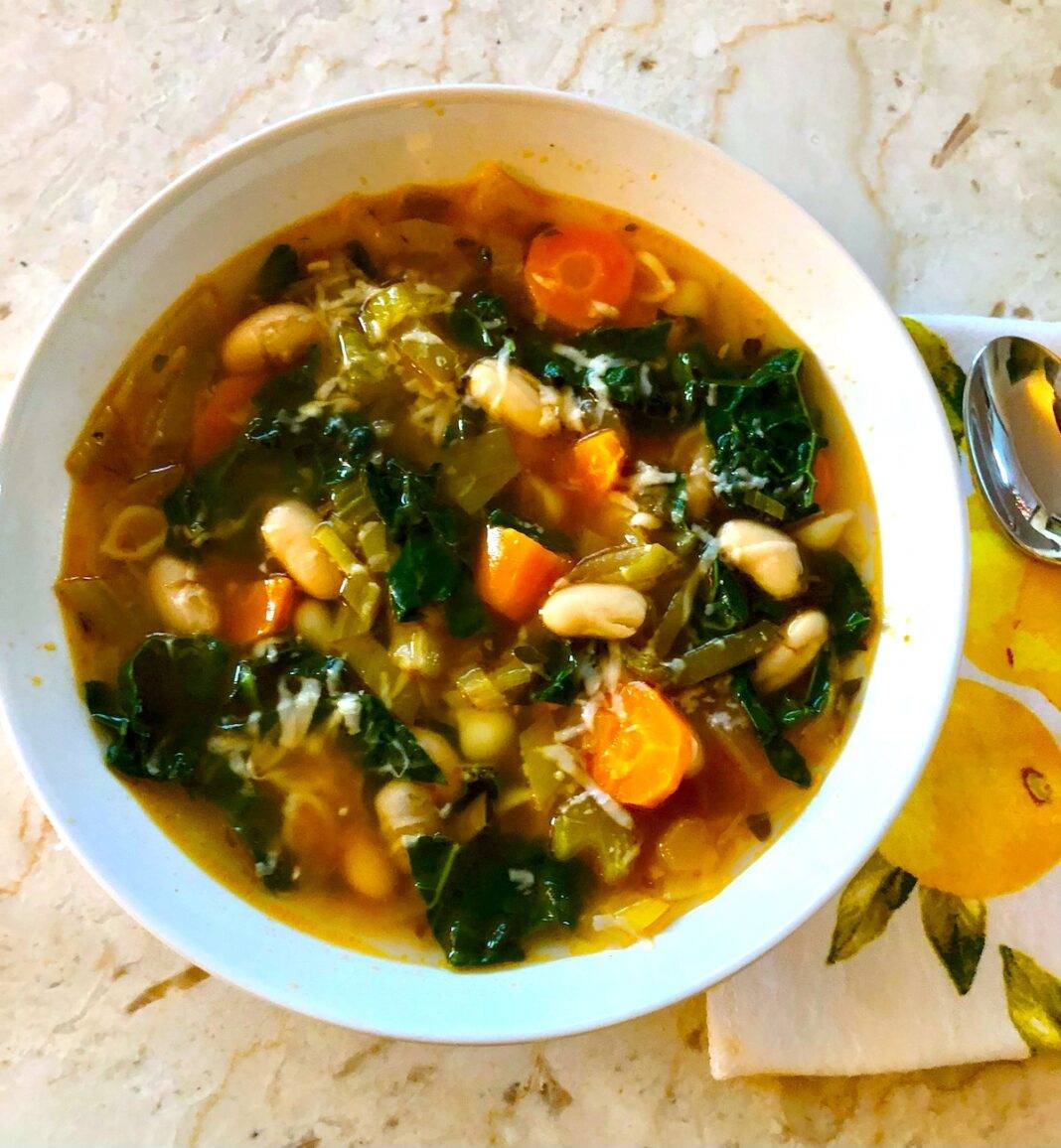 Bowl of soup with kale, carrots and white beans
