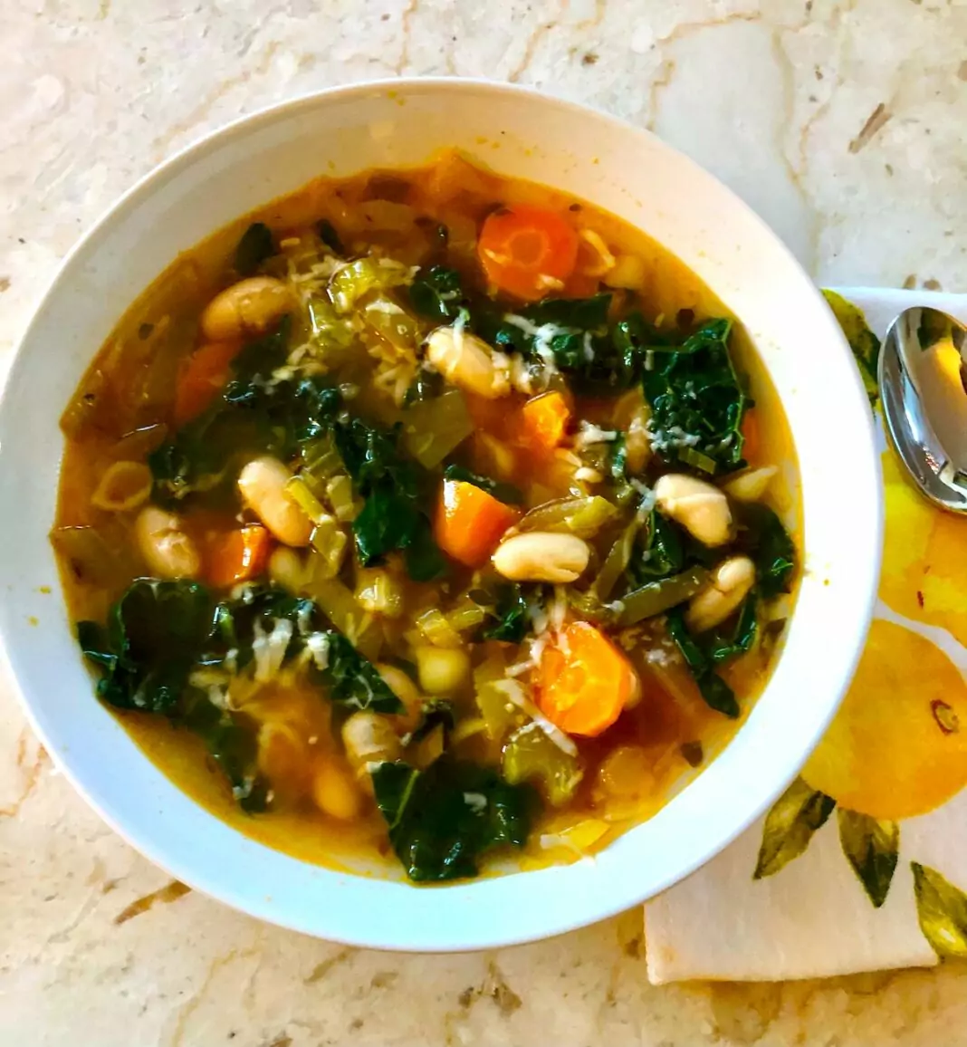 Bowl of soup with kale, carrots and white beans