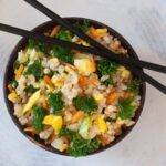Bowl of fried rice with vegetables with chop sticks