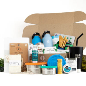 A cardboard box full of eco-friendly products, including Bee's Wrap, a loofah, stainlees steel food storage tins, Kleen Kanteen reusable beverage containers, bamboo cutlery, and more from sustainable online marketplace EarthHero.