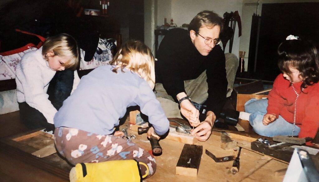 Father and children working together on DIY construction project.