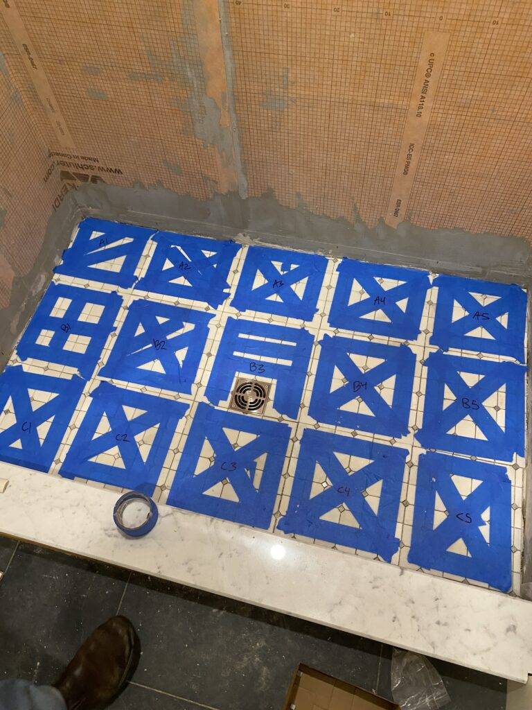 Blue painters tape marks out sections of tile.