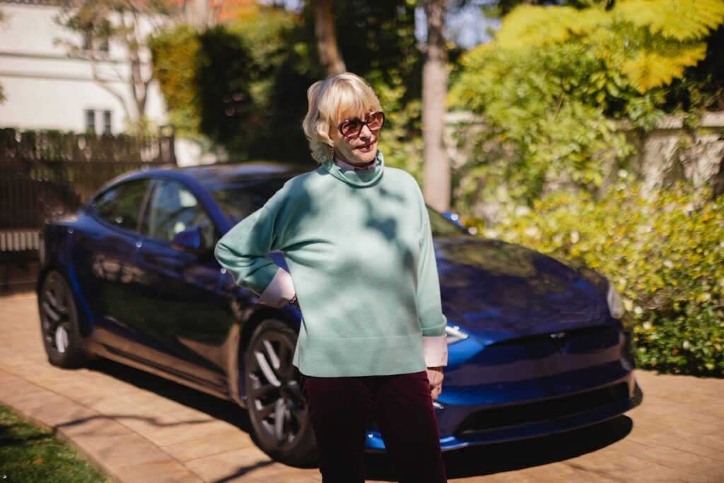 Lyn Lear in front of her Tesla.