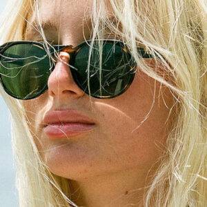 A blonde woman wears dark sunglasses.