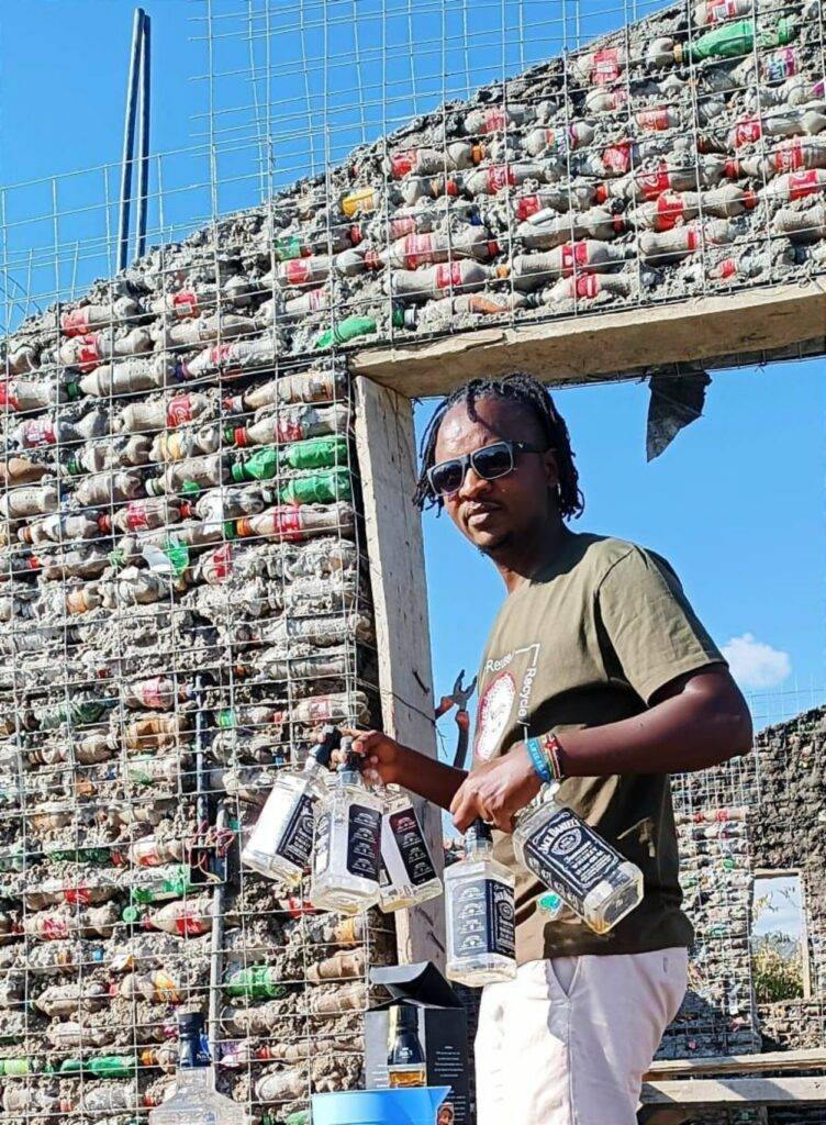 Izzo Mwangi with glass and plastic bottles.