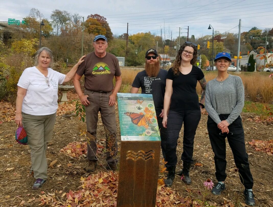volunteers in the field with pollinator sign