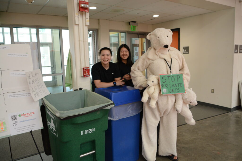 Students with a polar bear costume and a "stop private jets" sign