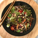 prepared noodle salad in bowl with chopsticks