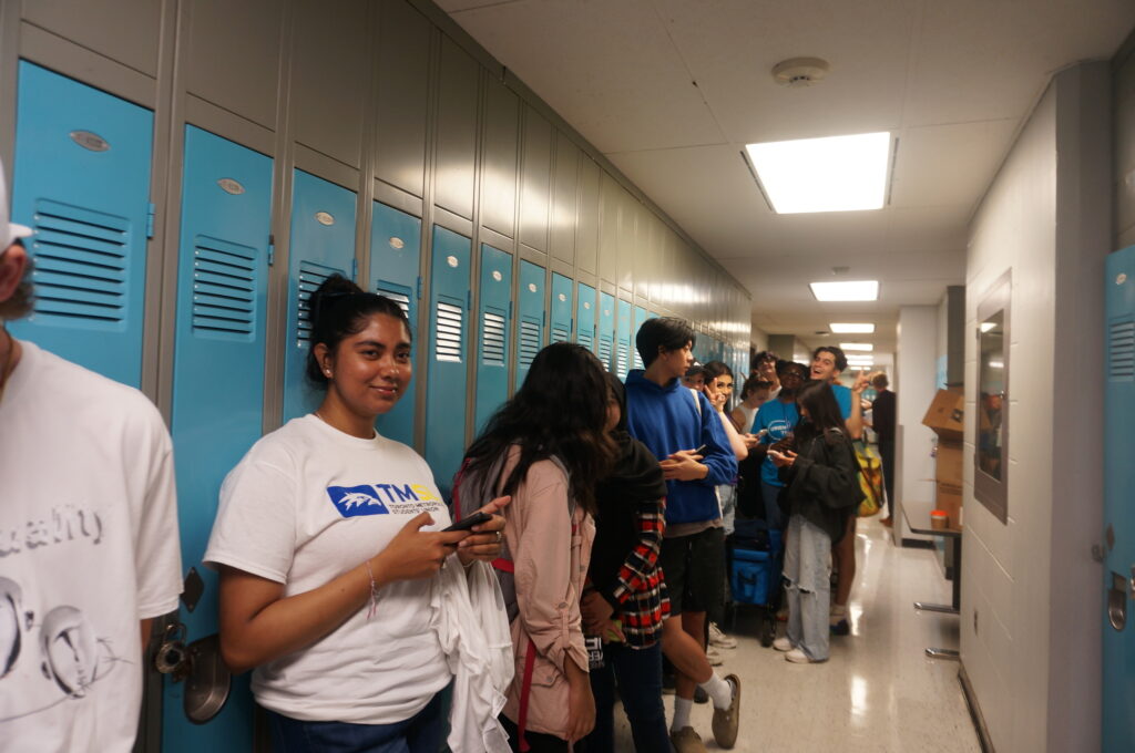 line of students by lockers in university hallway
