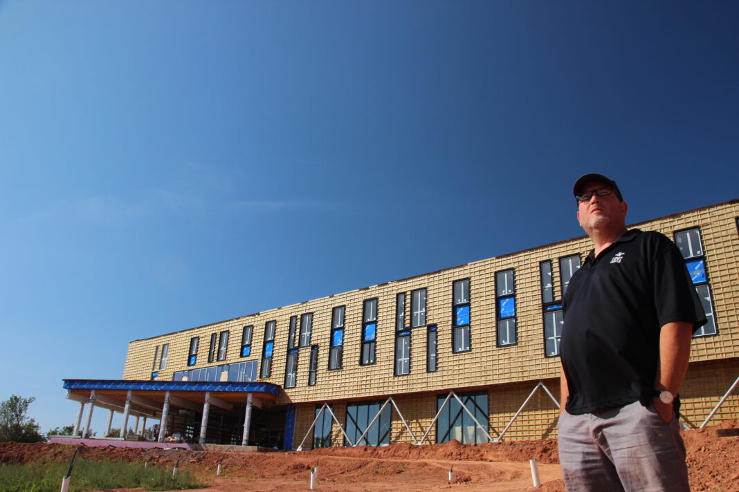 man stands in front of constructed building