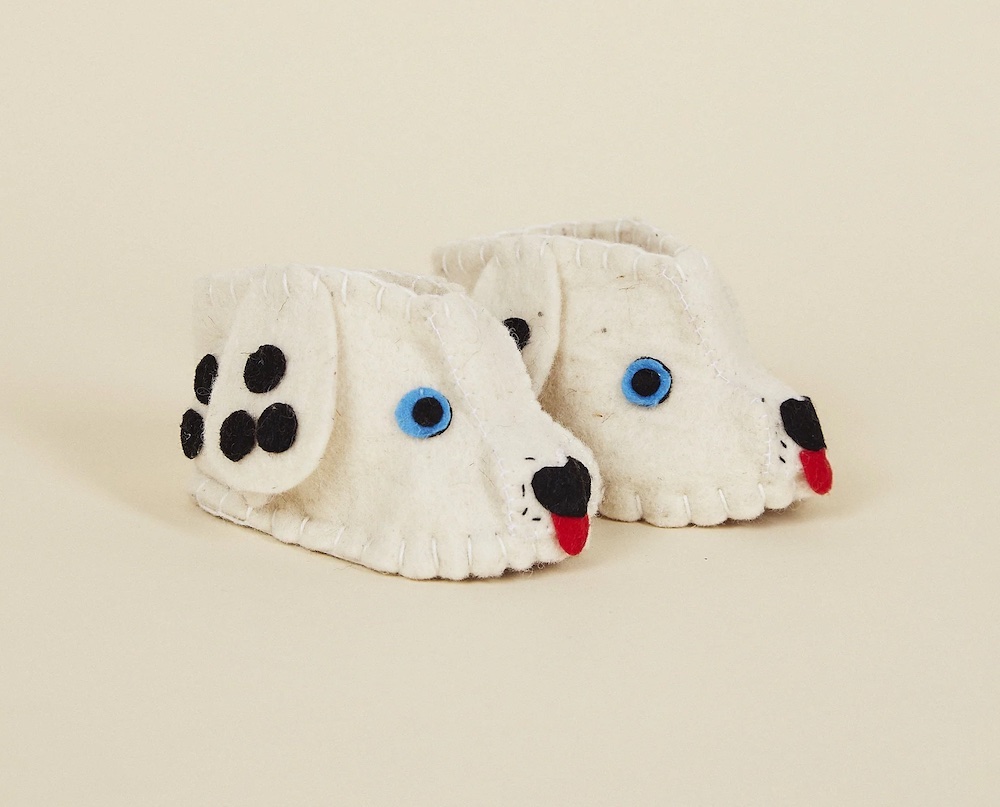 A pair of wool felt baby booties made to resemble a Dalmatian dog.