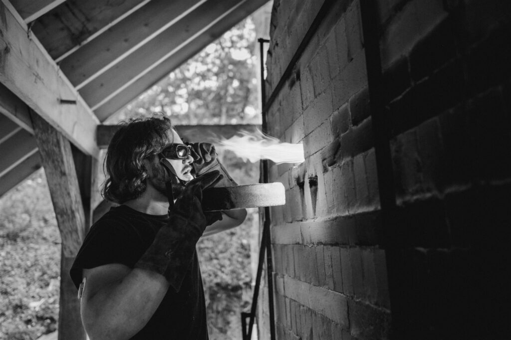 man looking into kiln with goggles on