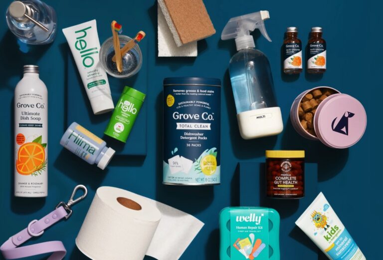 A navy background with assorted products on it, including toothpaste, dish soap, a dog leash, toilet paper, a spray bottle, dish detergent packs, gut health vitamins, sponges, and more, many with the house brand label, Grove Co., for sustainable online marketplace Grove Collaborative.