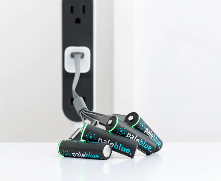 Four black AA batteries with the brand name โpaleblueโ are charging on a micro-USB charger.
