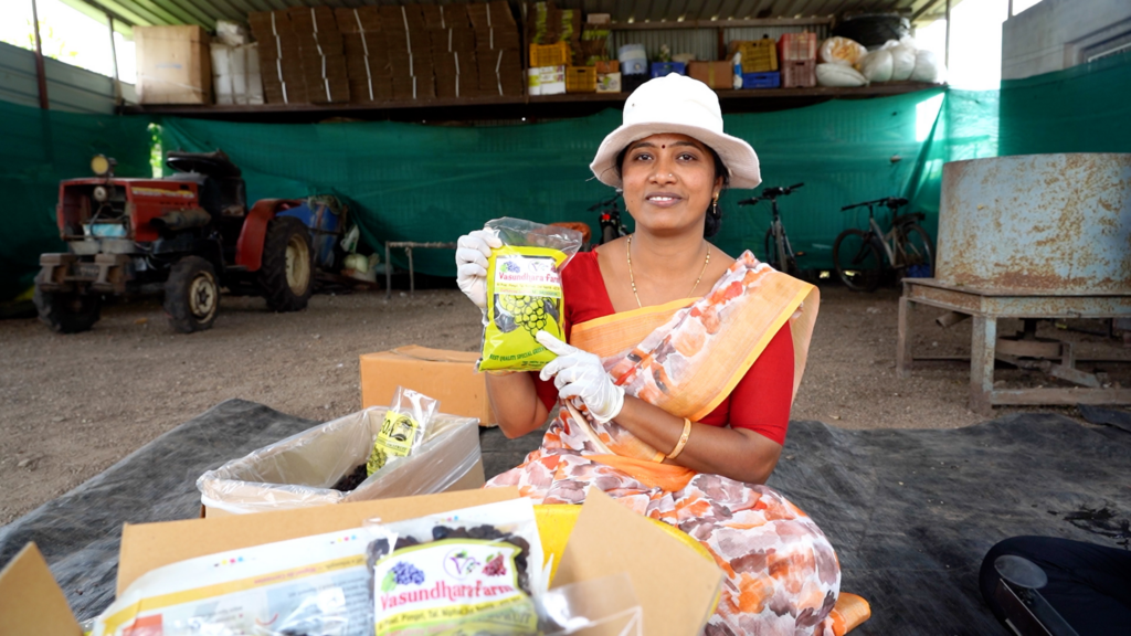 Woman holds up a package of solar-dried raisins.