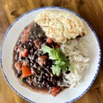 jerk black beans, roti and rice on a plate