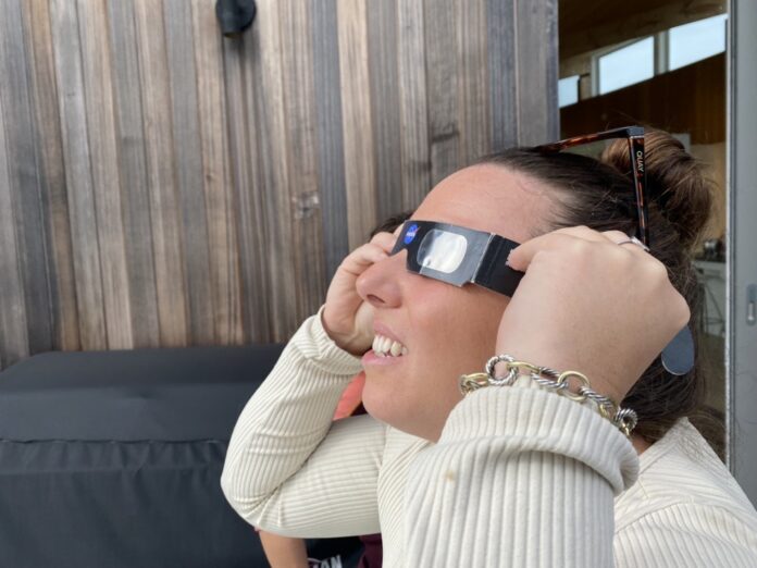 person wearing solar eclipse glasses