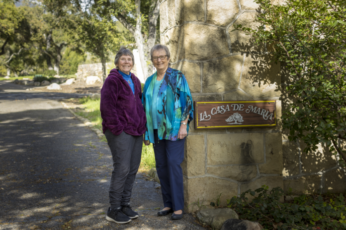 Two women stand at the entrance of La Casa de Maria