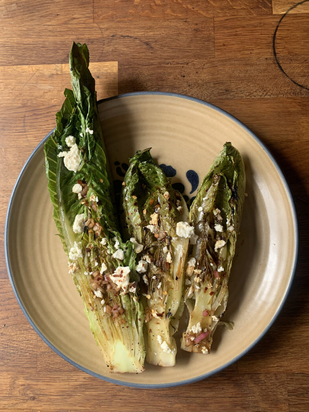 lettuce leaves on a plate topped with feta cheese