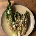 lettuce leaves on a plate topped with feta cheese