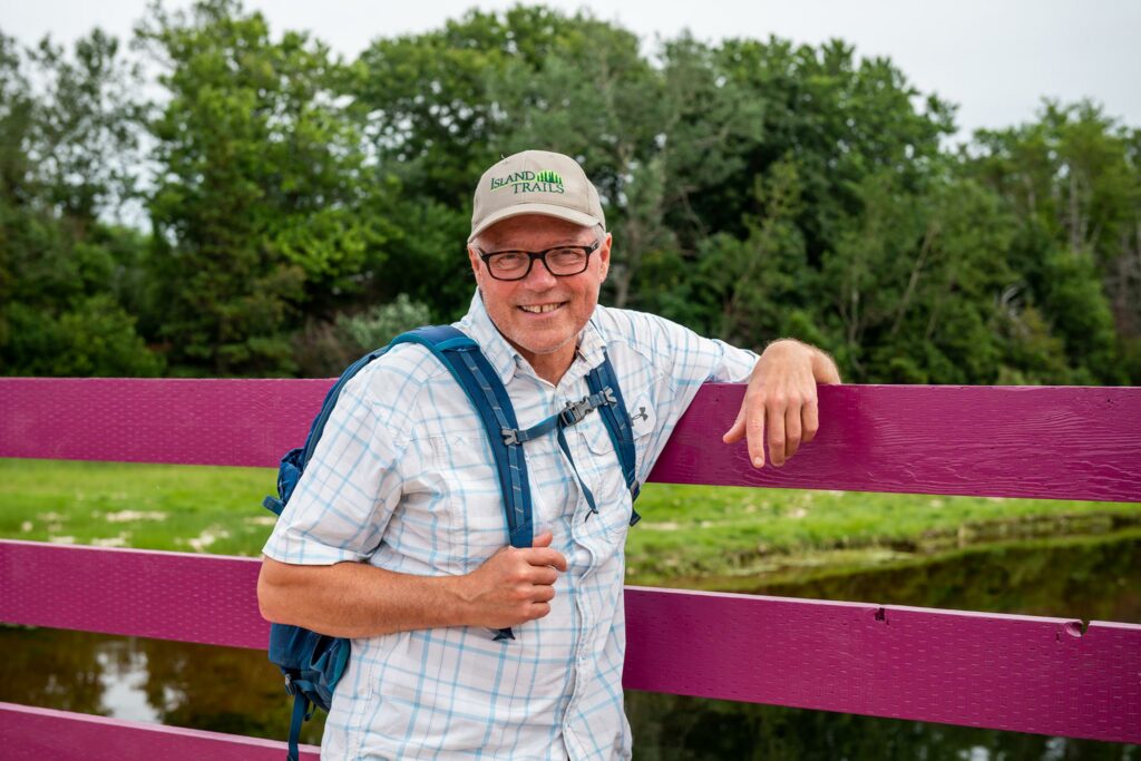 man standing by fence on trail