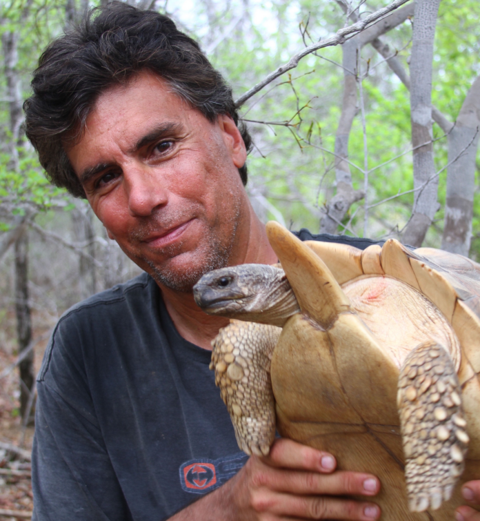 Craig Stanford holds a turtle.