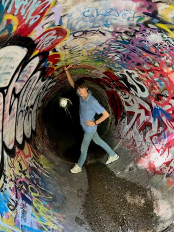A boy stands inside the Time Travel Tunnel.