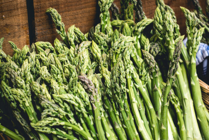 asparagus stalks on a brown wood table