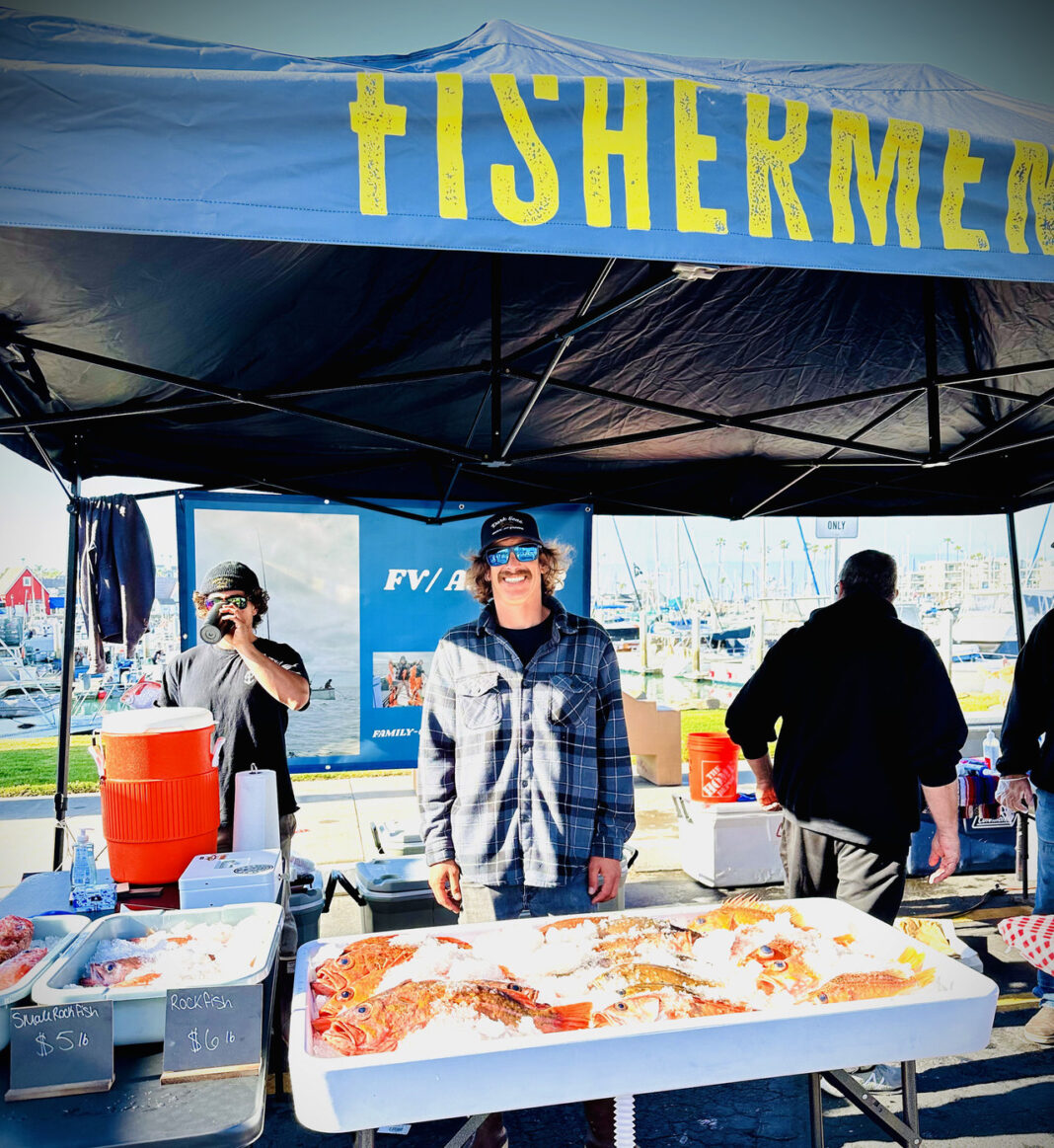 fisherman with catch at outdoor market