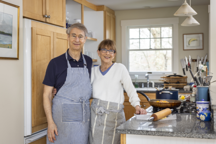 A couple stand in their kitchen.