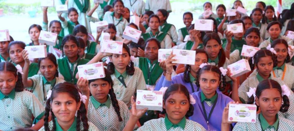 girls in school uniforms holding packages of Sanitrust