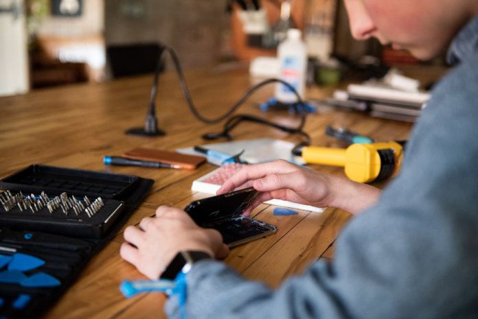 iFixit member Moses Buckwalter cracks a phone.