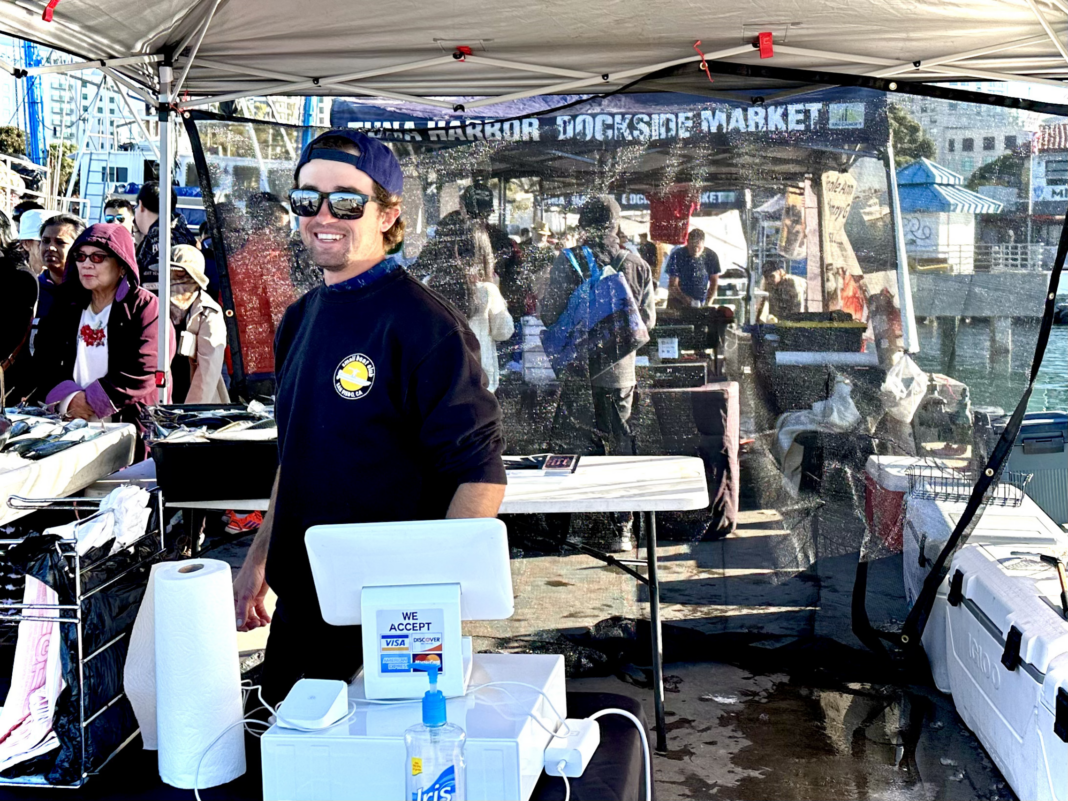 man at register at fish market