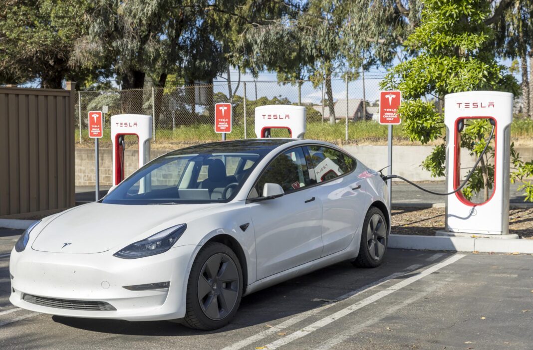 white Tesla EV at charging station