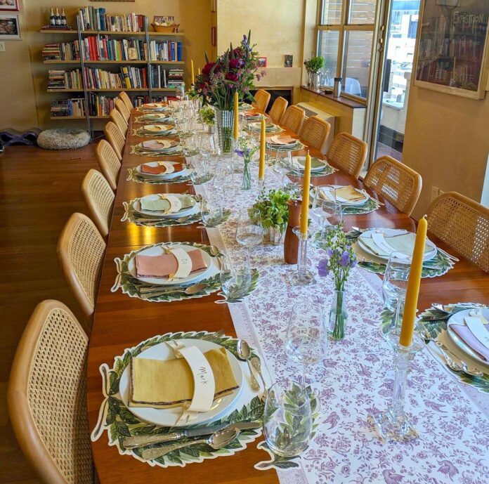 dining room table set with plates napkins and candles
