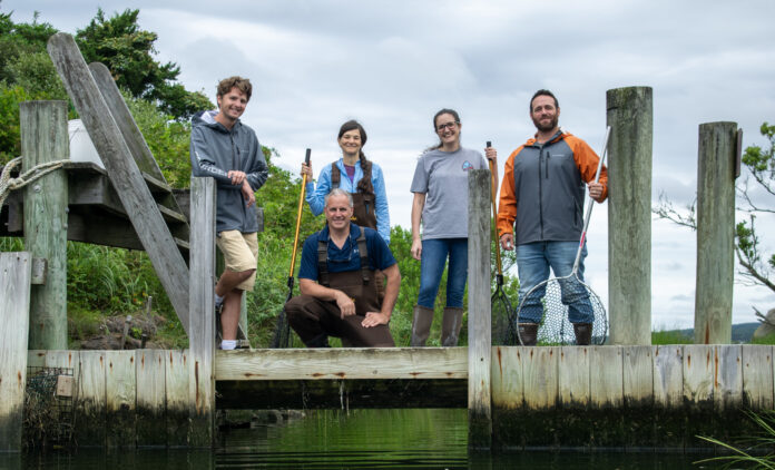 people standing on dock by river
