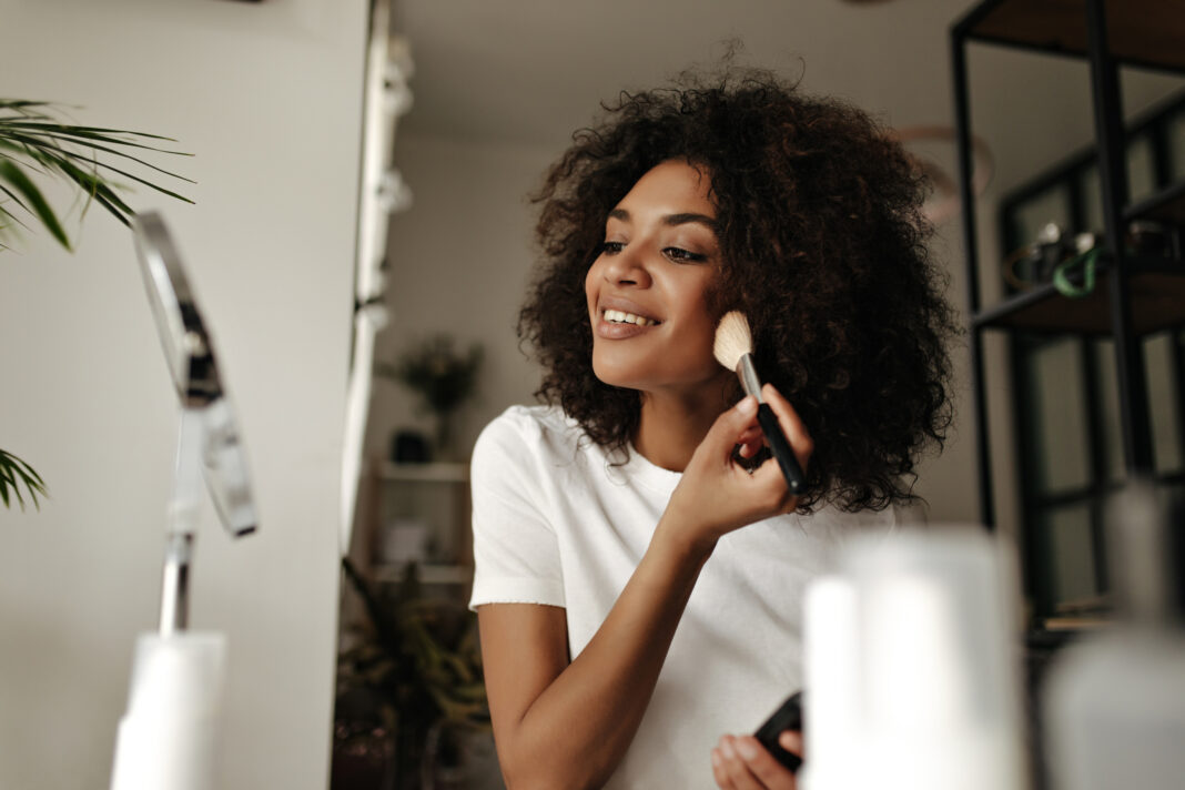 woman applying makeup at home