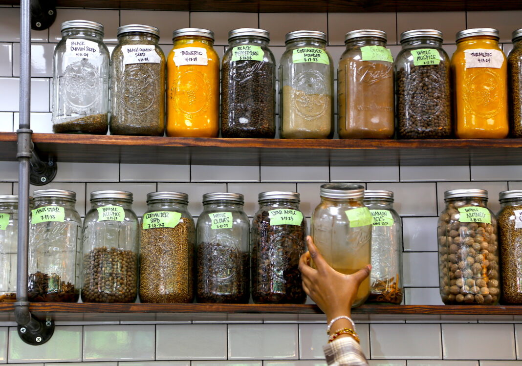 a person grabs from a shelf full of spices