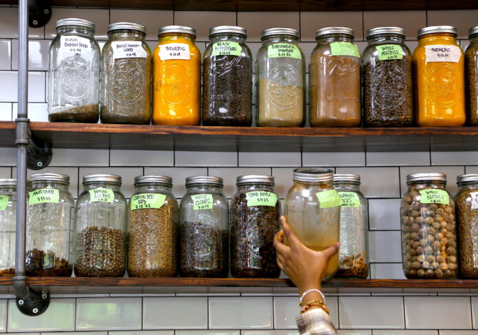 a person grabs from a shelf full of spices