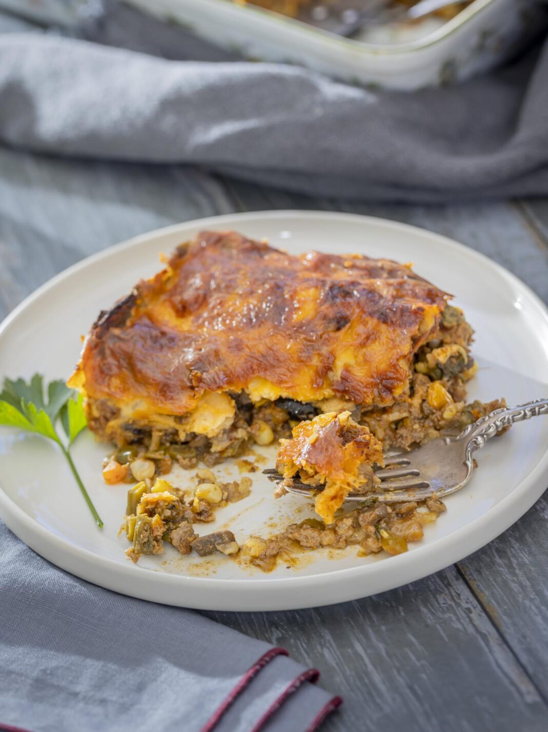 an enchilada casserole on a plate with a fork