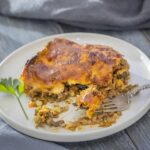 an enchilada casserole on a plate with a fork