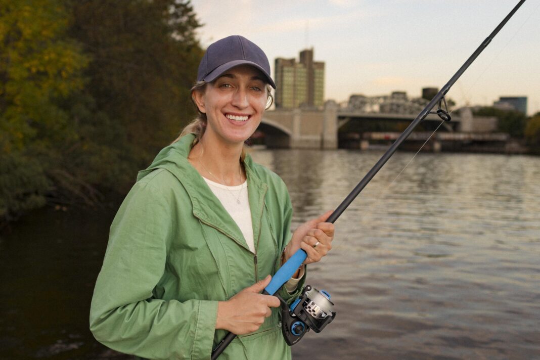 a woman holding a fishing pole and smiling