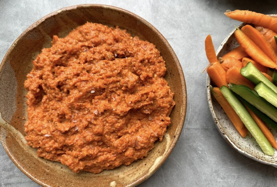 an orange dip with veggies on the side