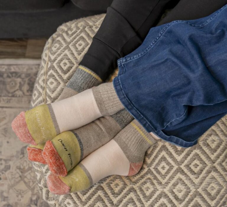 Two pairs of feet in socks with the brand name Darn Tough