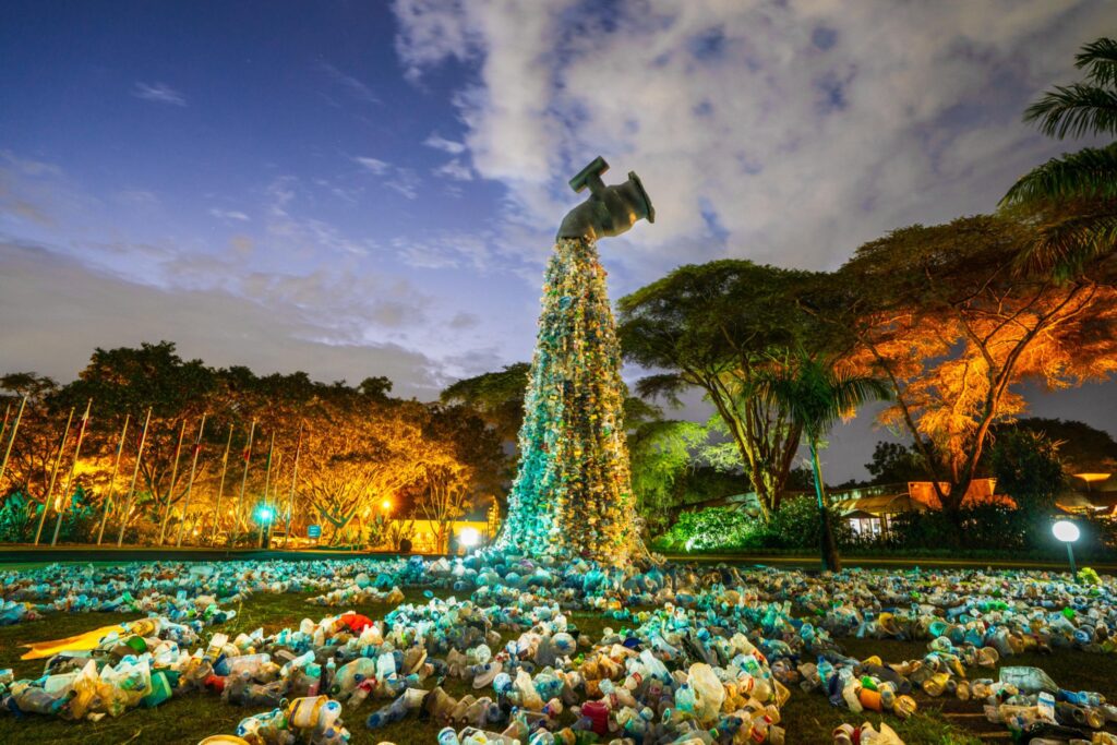 A giant plastic tap pours plastic onto the lawn outside of the United Nations headquarters in Kenya