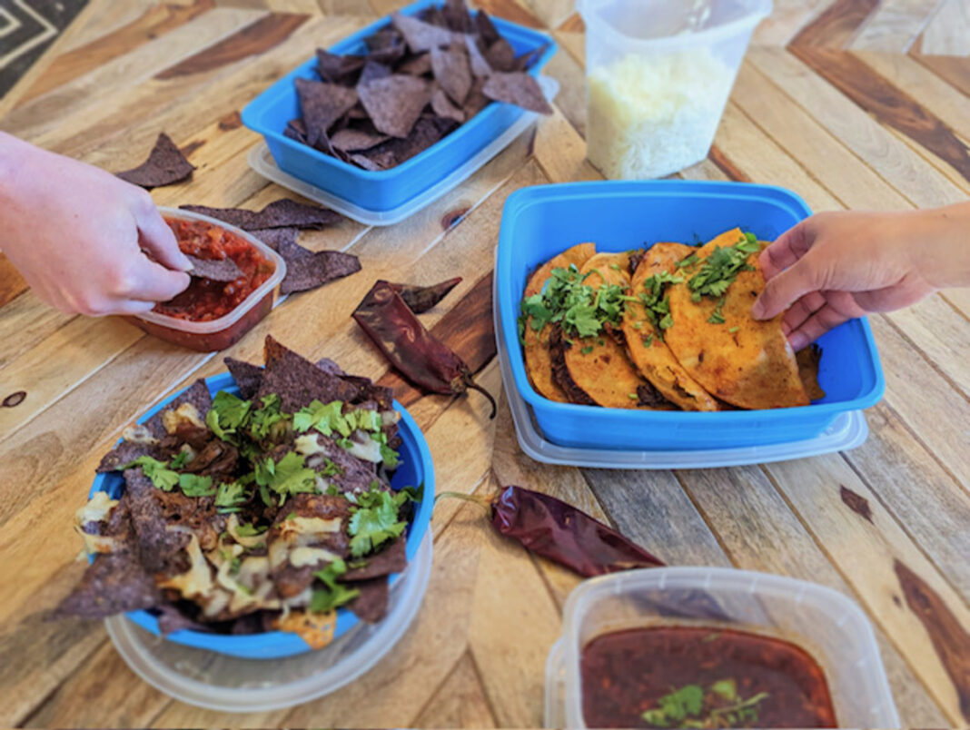hands grabbing food from takeout containers